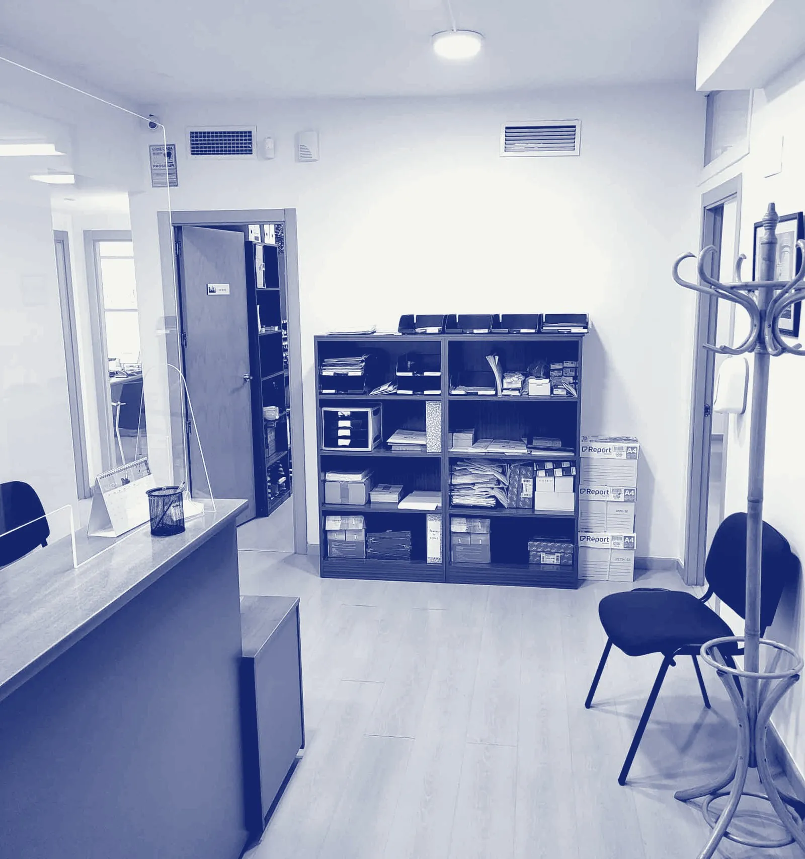 Recepción del despacho, con el mostrador de atención y la sala de espera.